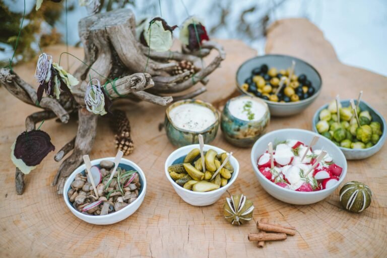 Assorted appetizers displayed on a rustic wooden table outdoors, perfect for a festive gathering.